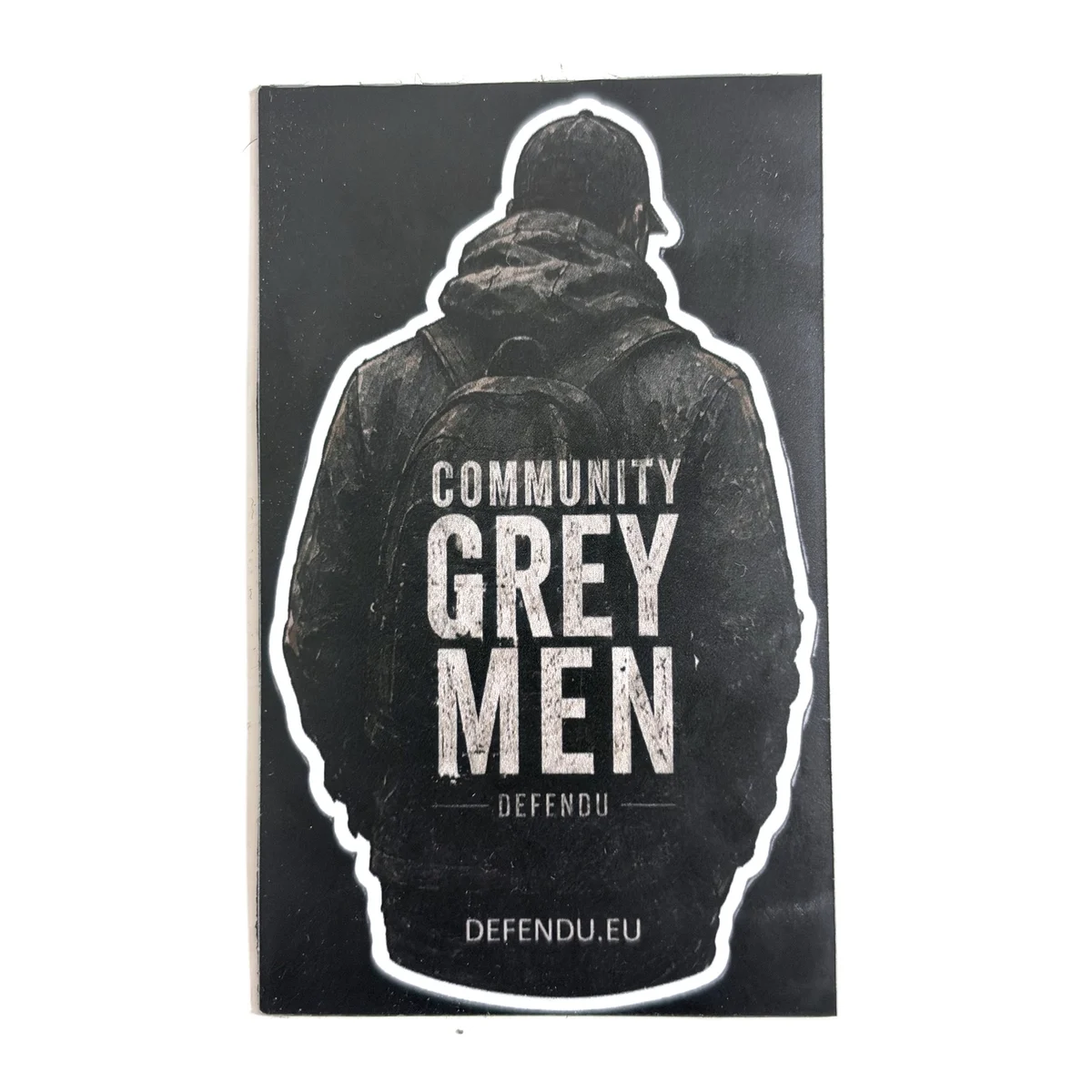 Czarny magnes z sylwetką Grey Men Community i napisem DEFENDU.EU