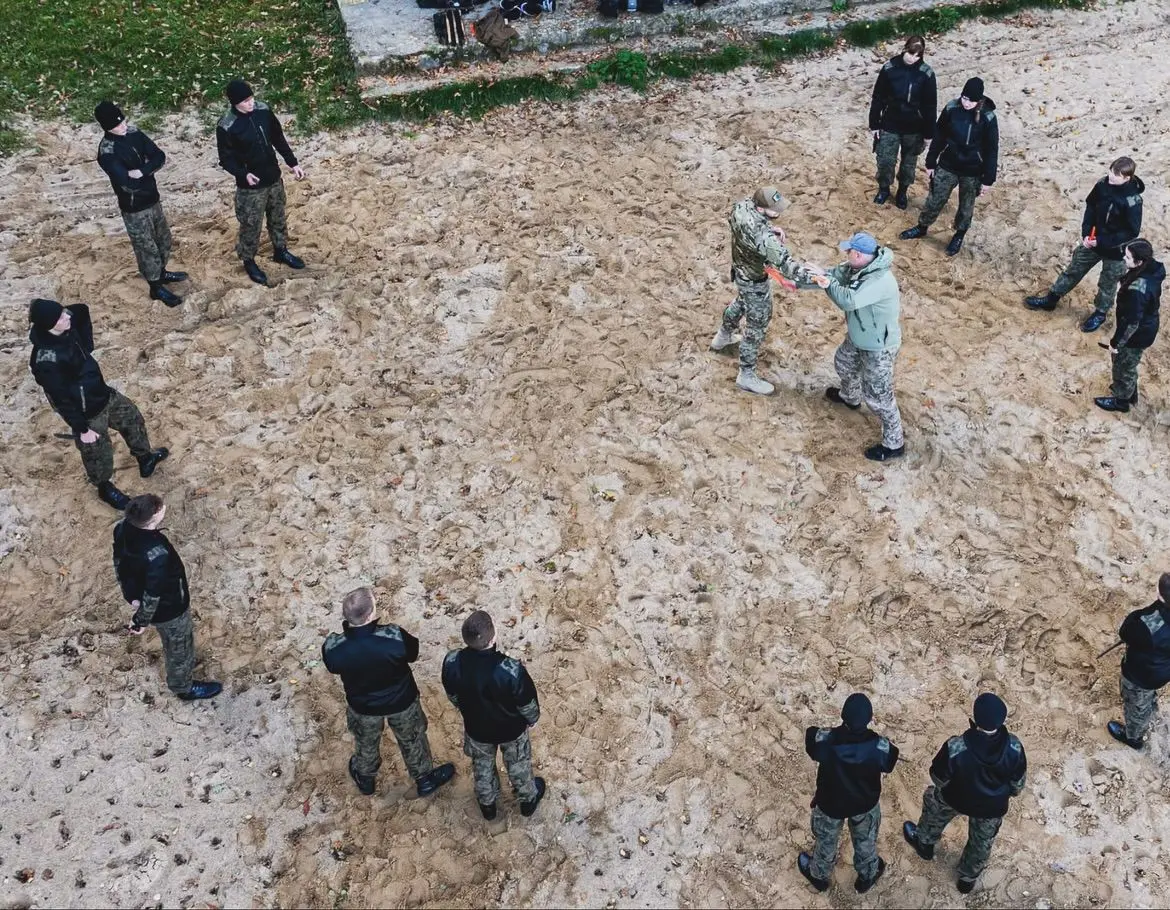 Uczniowie ćwiczą w parach na plaży — widok z góry